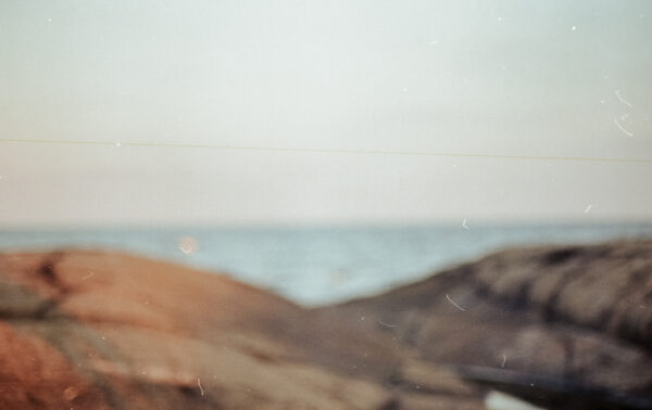 Oskarpt analogt fotografi av klippor vid en strand